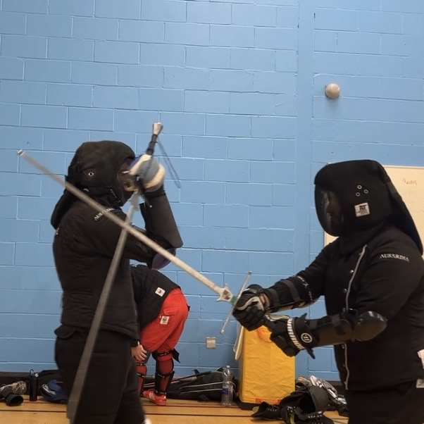 Olgun Tiltay learning Longsword blocking from Cosmas Cieplak-Mayr von Baldegg HEMA instructor in Ausardia